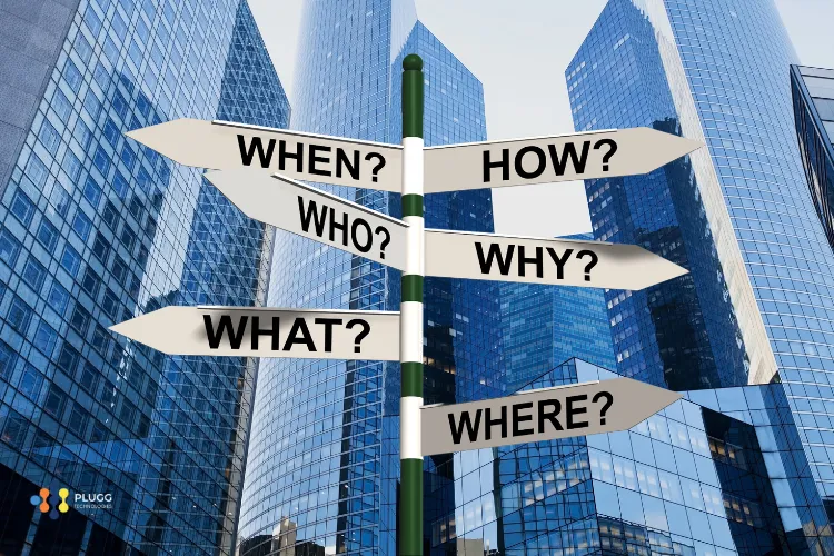 A signpost featuring questions like when, how, and where, is erected in front of an office building in LATAM to represent all the questions about hiring IT talent from Latin America.