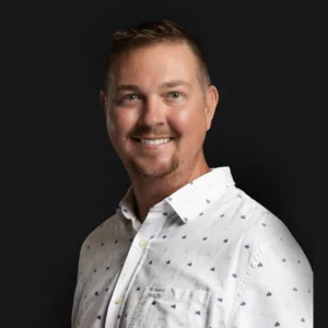 Brian Samson, a LATAM talent acquisition specialist at Plugg Technologies, stands in a white shirt before a black backdrop.