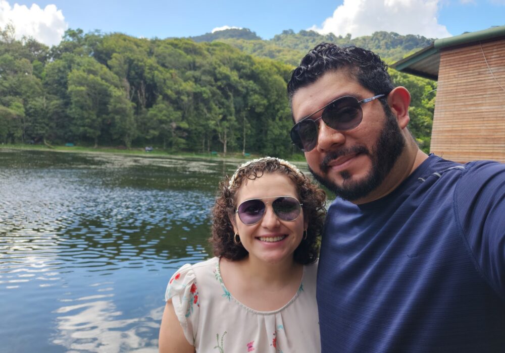 Jason Campos and his wife Tati smile in front of lake in Nicaragua