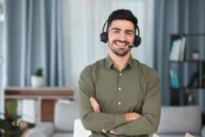 A smiling male virtual assistant from Latin America standing in a green shirt